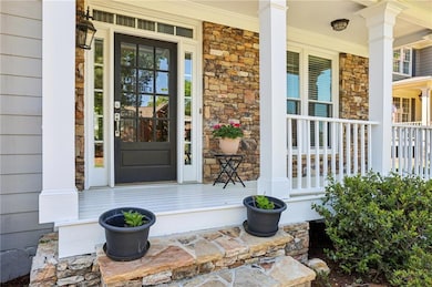 Entrance to property with stone siding and covered porch