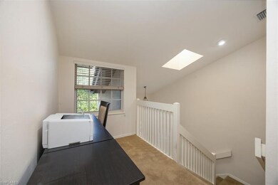 Carpeted office featuring vaulted ceiling with sky