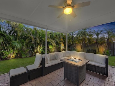 Fenced backyard with an outdoor living space with a fire pit, a patio area, and a ceiling fan