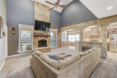 Living room featuring light carpet, a stone firepl