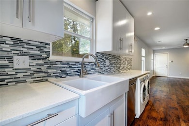 Kitchen with recessed lighting, white cabinetry, dark wood-style floors, decorative backsplash, and light stone countertops