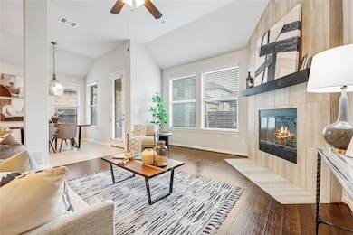 Living area with lofted ceiling, a tiled fireplac