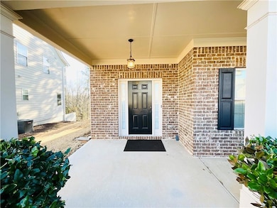 Doorway to property with brick siding and central 