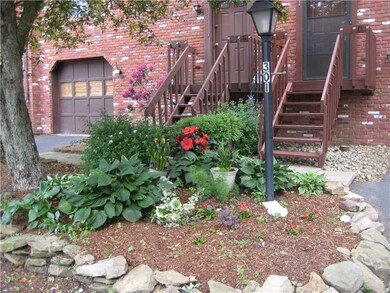 Exterior Front. Mature plantings and tree frame th