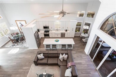 Living room with wood finished floors, a high ceiling, and ceiling fan