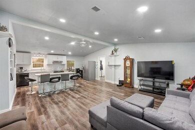 Living room with ceiling fan, vaulted ceiling, and