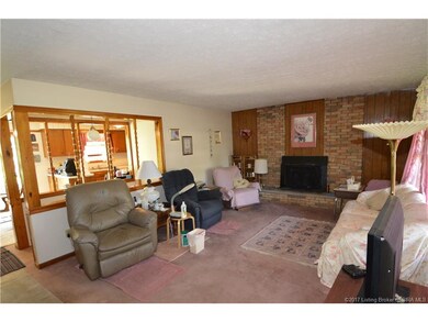 Living room wall is open for view of the kitchen a