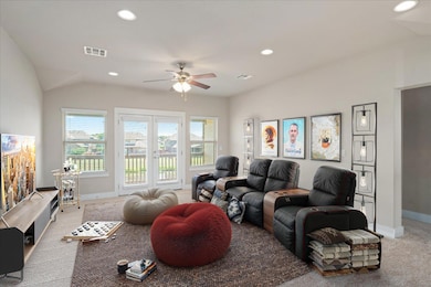 Carpeted living area with a ceiling fan, baseboar