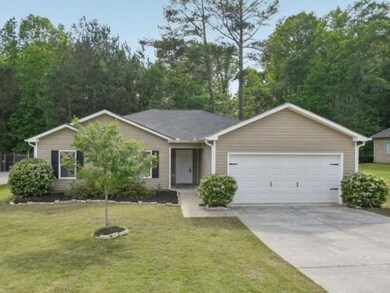 Ranch-style house featuring concrete driveway, a front yard, cooling unit, and an attached garage