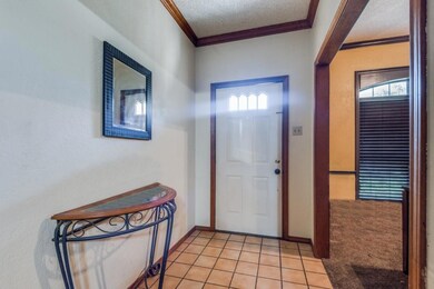 Tiled foyer featuring a textured ceiling, a wealth