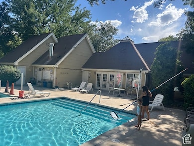 Community pool with a patio and french doors