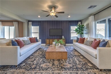 Living area featuring ceiling fan and wood walls