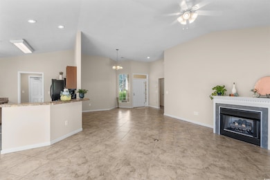 Kitchen with hanging light fixtures, light stone c