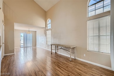 Empty room with high vaulted ceiling, a chandelier
