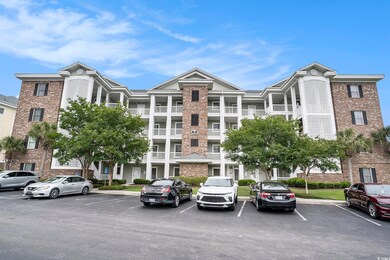 View of apartment building / complex featuring uncovered parking