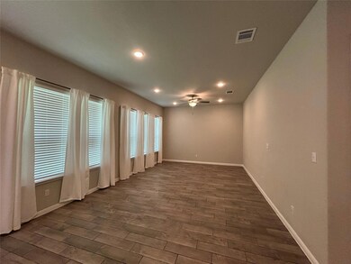 Empty room featuring ceiling fan, dark wood-style