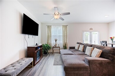 Living area with wood finished floors and ceiling fan