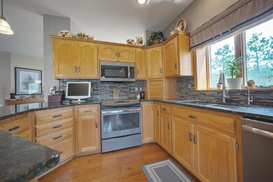 Open design living room/kitchen/dining room area has 9 ft ceilings, granite counter tops, stainless steel appliances, real hardwood flooring, and a gorgeous gas fireplace.