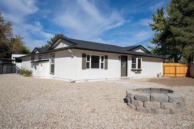 View of front facade with an outdoor fire pit, roof with shingles, and crawl space