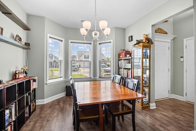 Dining area with a chandelier and dark wood-style floors