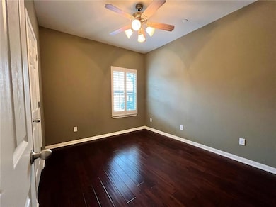 Spare room with dark wood-style flooring and ceiling fan