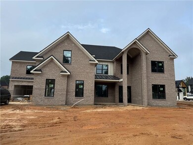 View of front facade with brick siding, a standing seam roof, and a metal roof