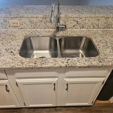 Details featuring a sink, light stone counters, w