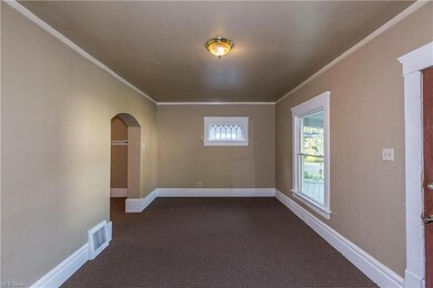 Carpeted empty room featuring crown molding