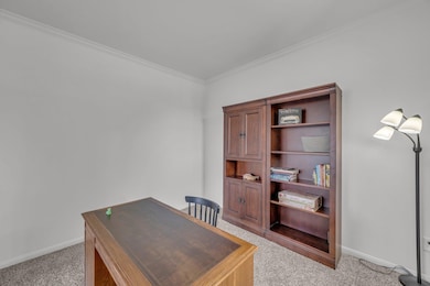 Office space with light carpet, baseboards, and o