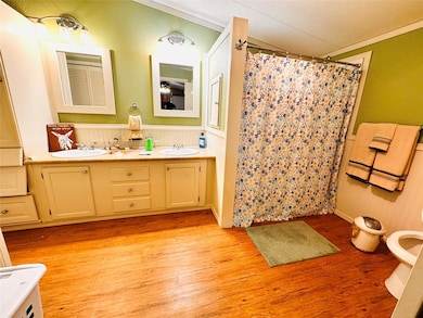 Bathroom featuring crown molding, wood finished fl