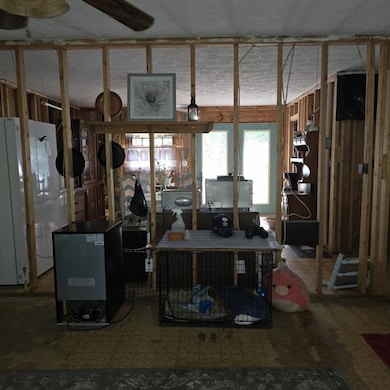 This is from the front door standing in the front room with space to the right and left with a fireplace to the right. Looking through a wall into the kitchen.