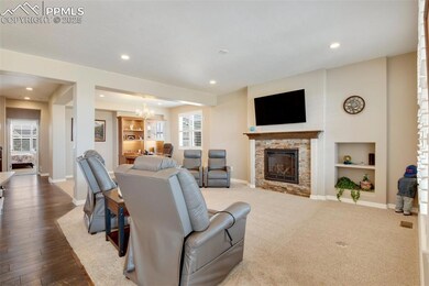 Main level great room with adjacent office boasts a gas log fireplace and built-in shelves.