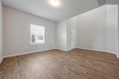 Empty room featuring wood finished floors and bas