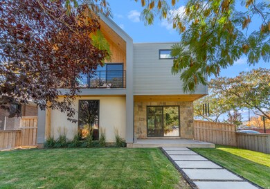 Rear view of property with a balcony, a patio, stucco siding, and stone siding