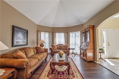 Living room with dark wood-style flooring, baseboa