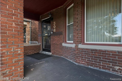 Property entrance with a porch and brick siding