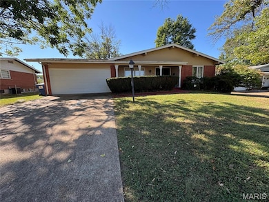 Single story home featuring brick siding, concrete driveway, a front lawn, and a garage