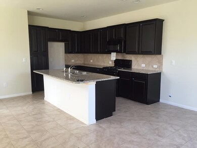 Kitchen featuring black appliances, dark cabinets