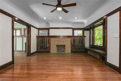 Large Living Room with original hardwood flooring, Leaded glass built-ins and wood burning fireplace.
