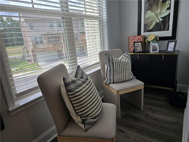 Living area with dark wood finished floors and baseboards