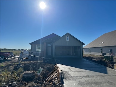View of front of home featuring board and batten siding, a garage, and asphalt driveway