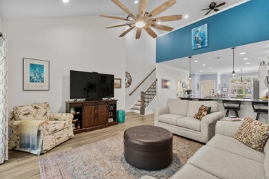 Living room featuring crown molding, stairs, a hig