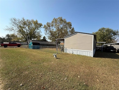 View of yard with a carport and fence