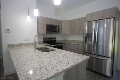 Kitchen featuring dark vinyl-type flooring, hangin