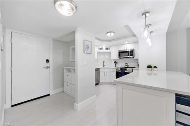 Kitchen featuring appliances with stainless steel finishes, a peninsula, a tray ceiling, light countertops, and white cabinetry