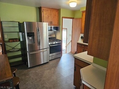 Kitchen featuring stainless steel appliances, backsplash, and dark tile floors