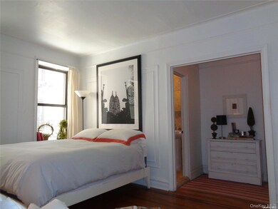 Bedroom with wood finished floors and baseboards