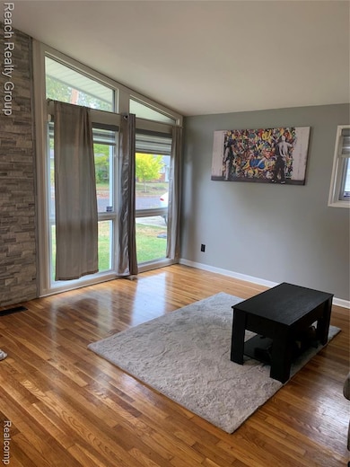 Living area with light wood-style floors and baseboards