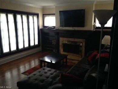 Beautiful wood floors and large windows in the Living Room with wood burning fireplace and built-ins on both sides.