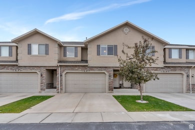 Traditional-style home featuring stucco siding, stone siding, and concrete driveway